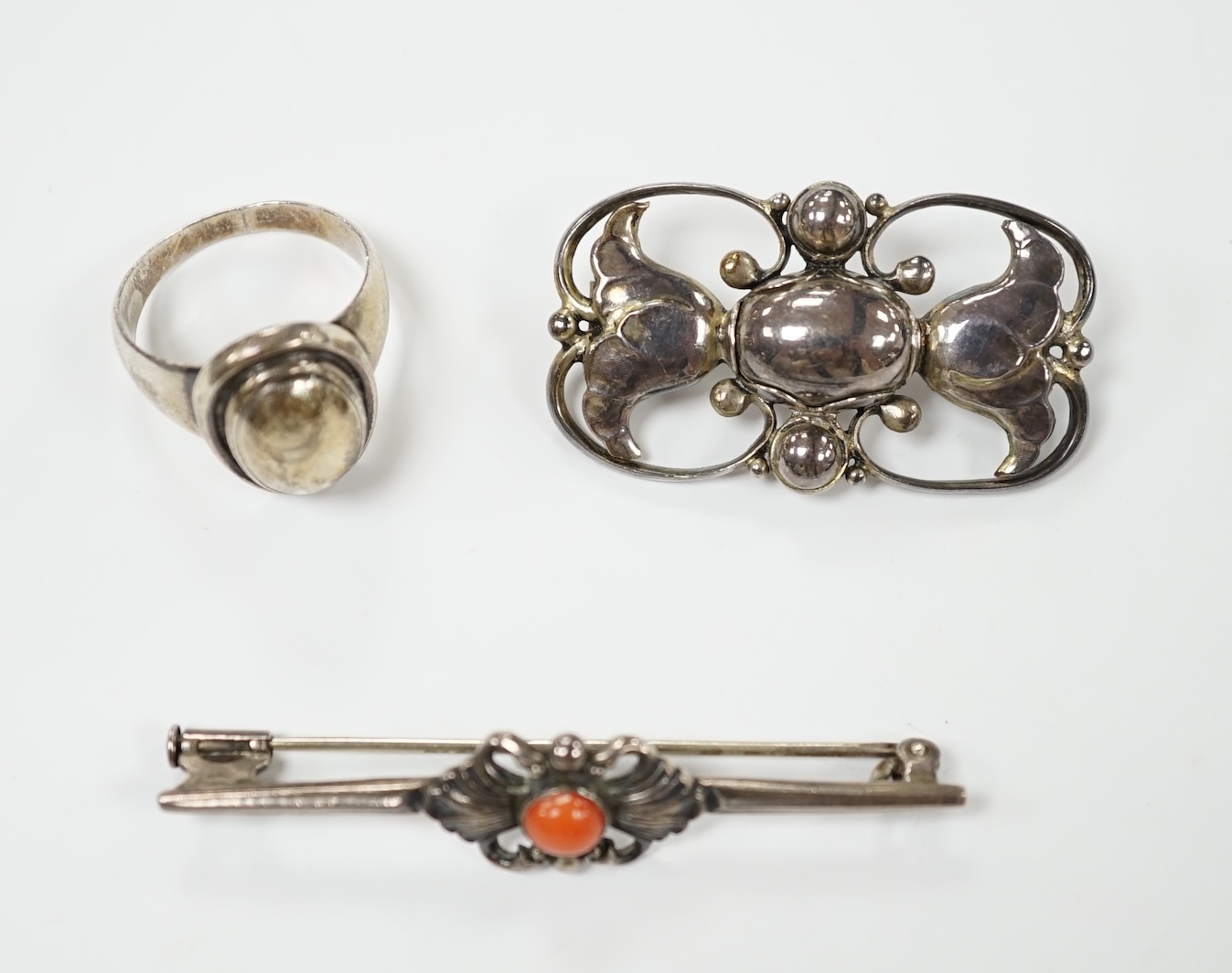 A Georg Jensen sterling and cabochon coral set bar brooch, design no. 214, 53mm, a similar Jensen brooch, design no. 236A, 37mm and a similar ring, design no. 46B, size M. Condition - fair to good